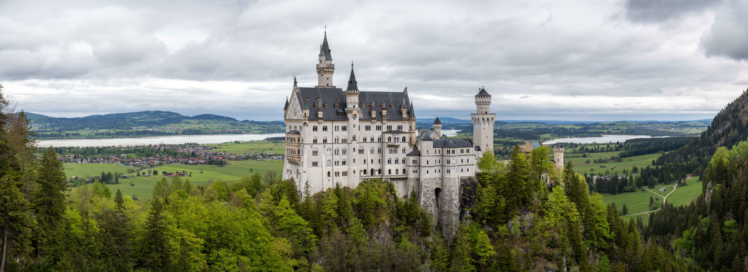 Die klassische Sicht von der Marienbrücke auf das Schloss Neuschwanstein, mit den umgebenden Seen im Hintergrund